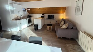 A modern apartment with a kitchen, dining area, and living room. - Appart 6 pers - proche pistes et vue montagne (Vars)
