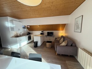 A modern apartment with a kitchen, dining area, and living room. - Appart 6 pers - proche pistes et vue montagne (Vars)