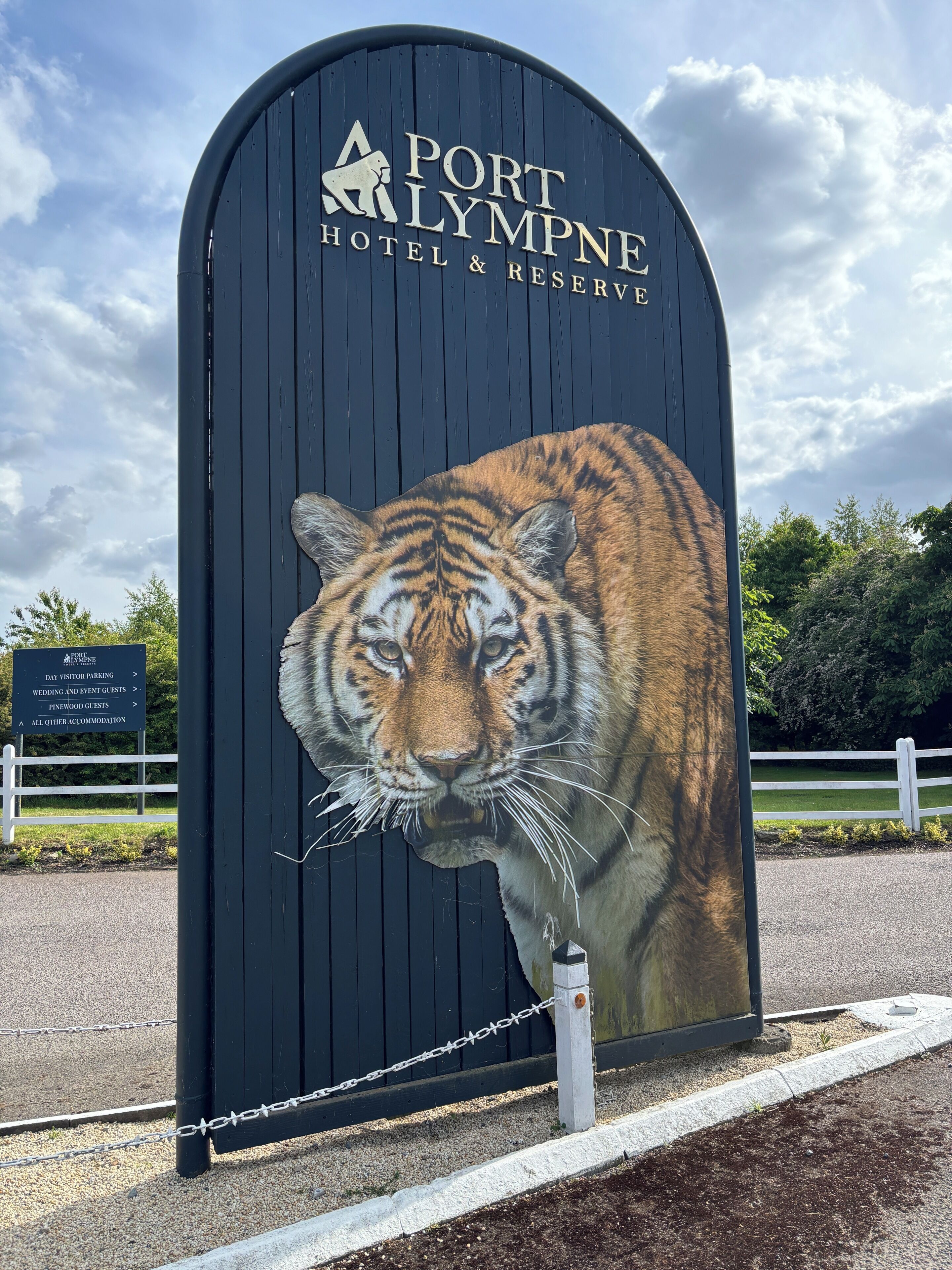 Ein schwarzes Schild mit einer Tiger-Illustration und dem Text 'Port Lympne Hotel & Reserve'.