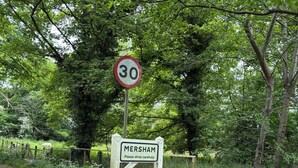 A speed limit sign and a location sign for Mersham.