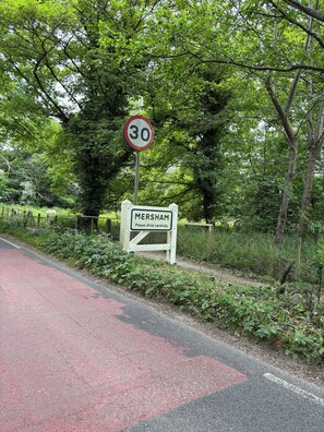 A speed limit sign and a location sign for Mersham.