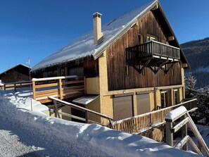 A wooden chalet with a balcony, surrounded by snow. - Appart 4 pers - proche pistes et vue montagne (Vars)