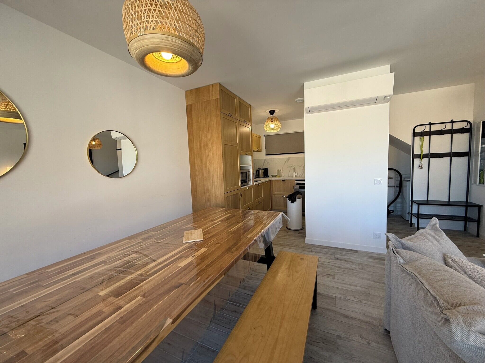Una cucina moderna con mobili in legno, un tavolo da pranzo e una panca.