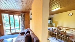Ein Holzinterieur mit einer Couch, einem Esstisch und Stühlen.