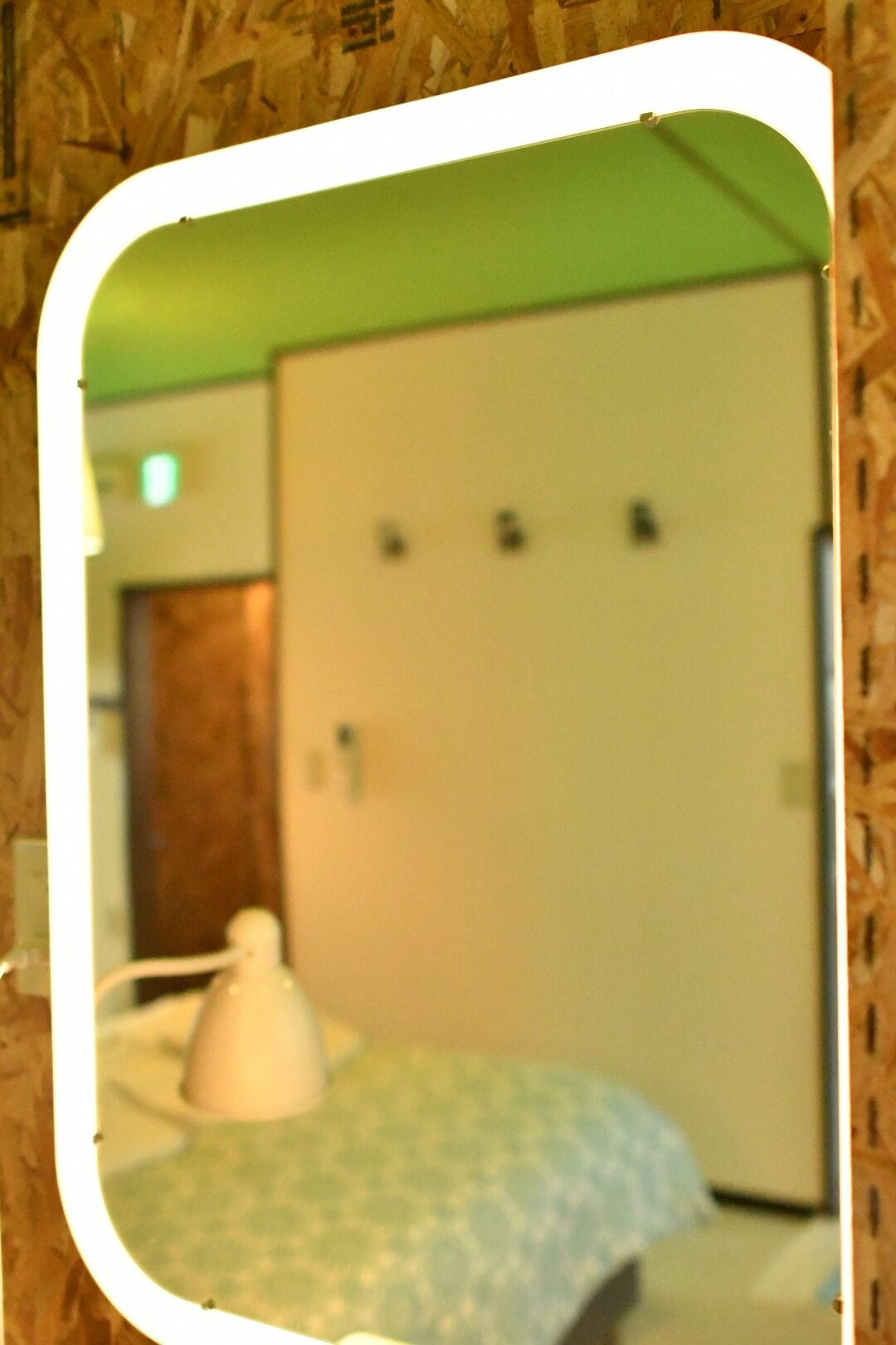 A room with a bed, a white lamp, and a door with a handle.
