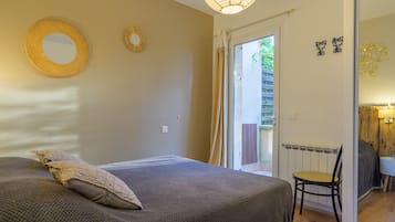 A bedroom with a bed, a chair, a window, and a door.