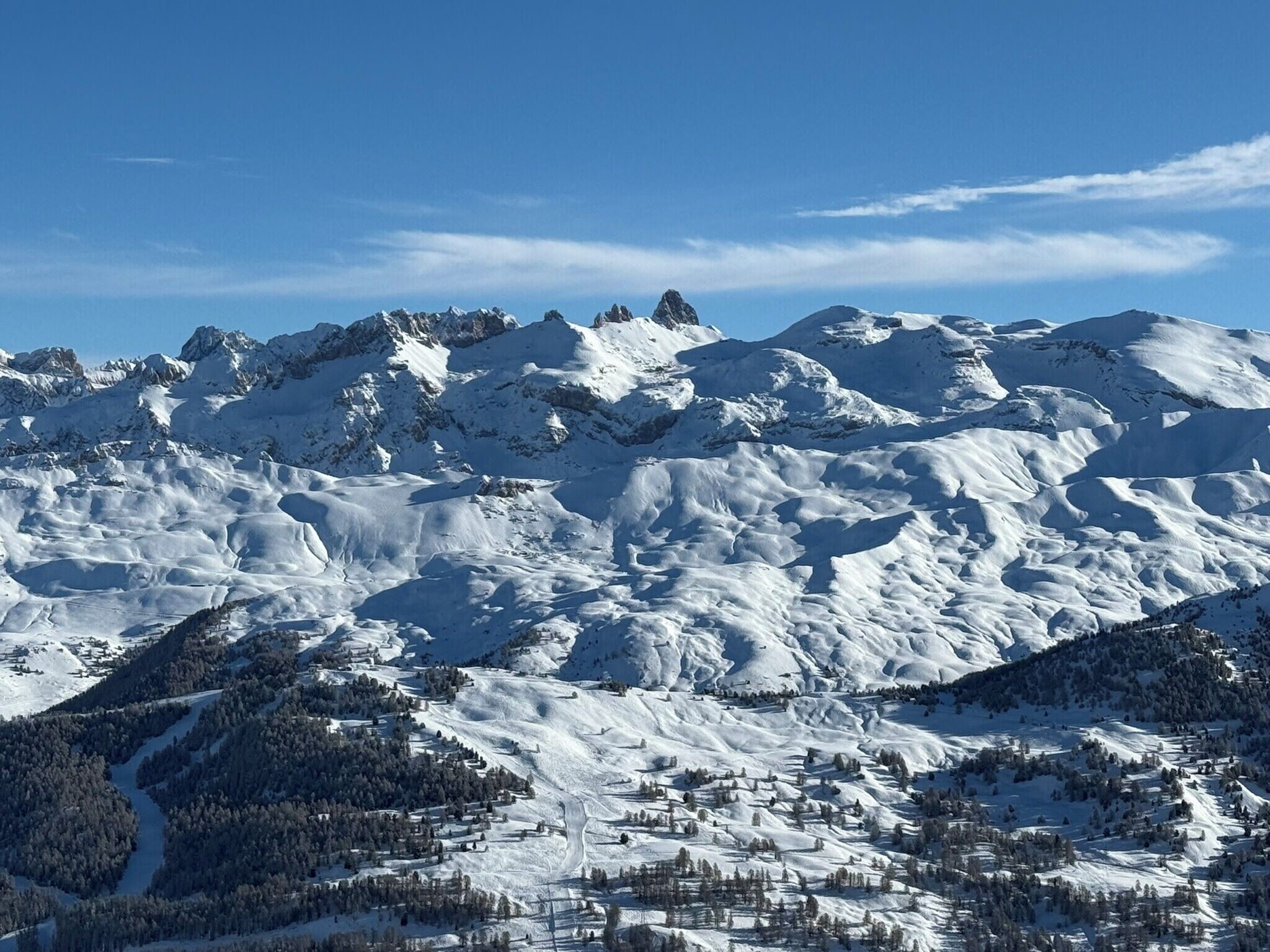A snow-covered mountain landscape with a ski resort in the foreground.