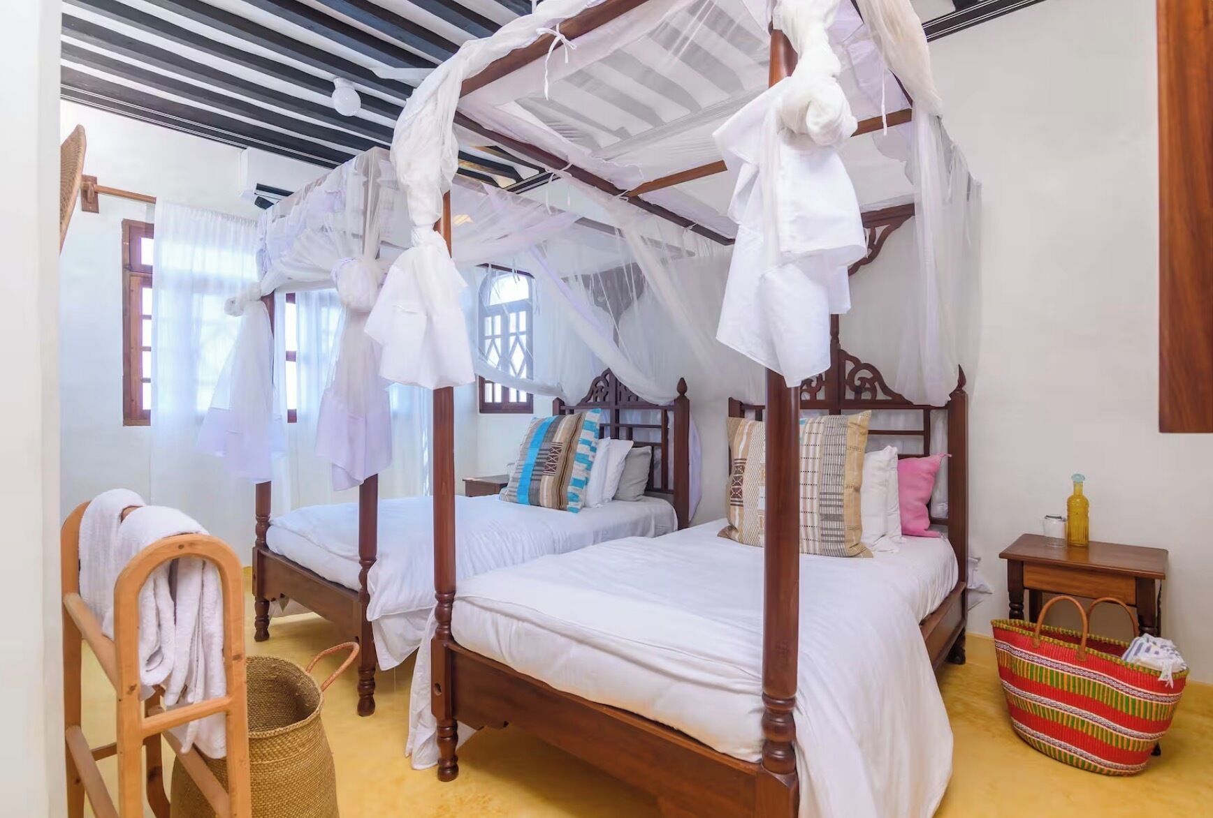 A four-poster bed with a canopy, wooden headboard, and white bedding.