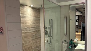 A modern bathroom with a glass-enclosed shower, a vanity with a sink, and a mirror. - Smith's Irish Pub & Accomodation (Vancouver)