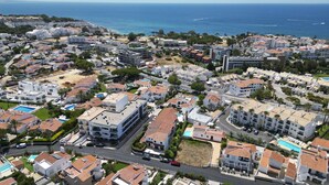 Eine Vogelperspektive eines Küstenwohngebiets mit mehreren Gebäuden, Straßen und einem Strand.