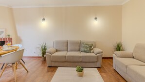 Ein Wohnzimmer mit einem beigefarbenen Sofa, einem Couchtisch und zwei Wandleuchten.