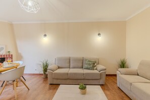 Ein Wohnzimmer mit einem beigefarbenen Sofa, einem Couchtisch und zwei Wandleuchten.