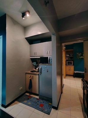 Une cuisine compacte équipée d’un réfrigérateur, d’un four et d’un four à micro-ondes.