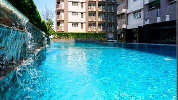 Una piscina con cascata, circondata da edifici residenziali a più piani.