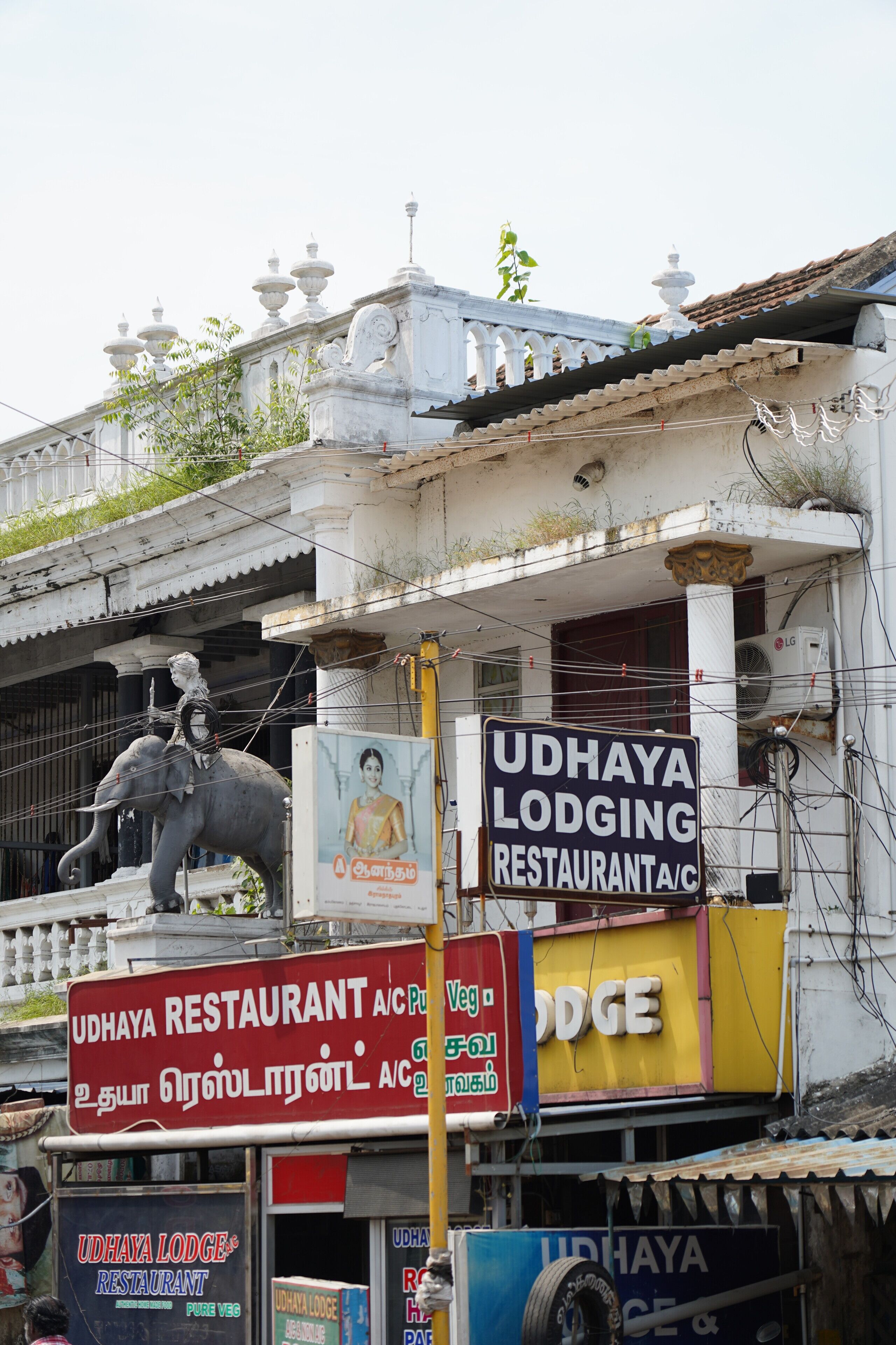 Um edifício com a placa do Restaurante Udhaya Lodge.
