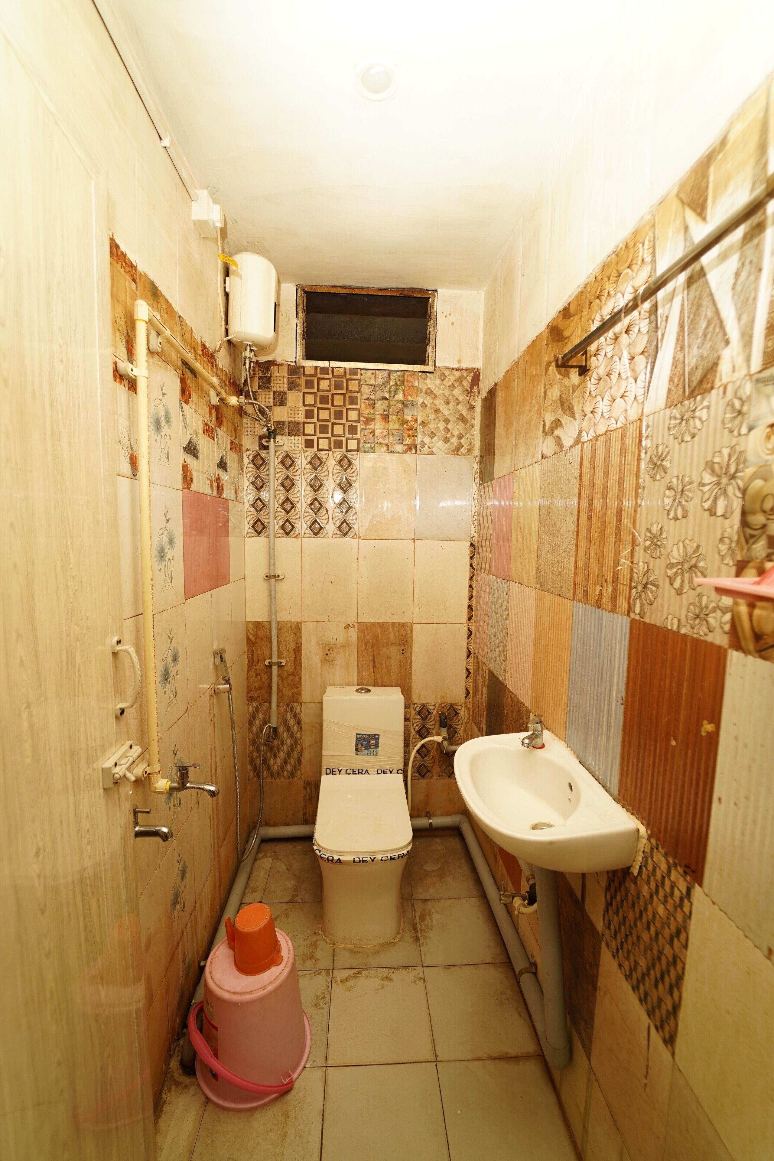 Un baño pequeño con inodoro, lavamanos y ducha.