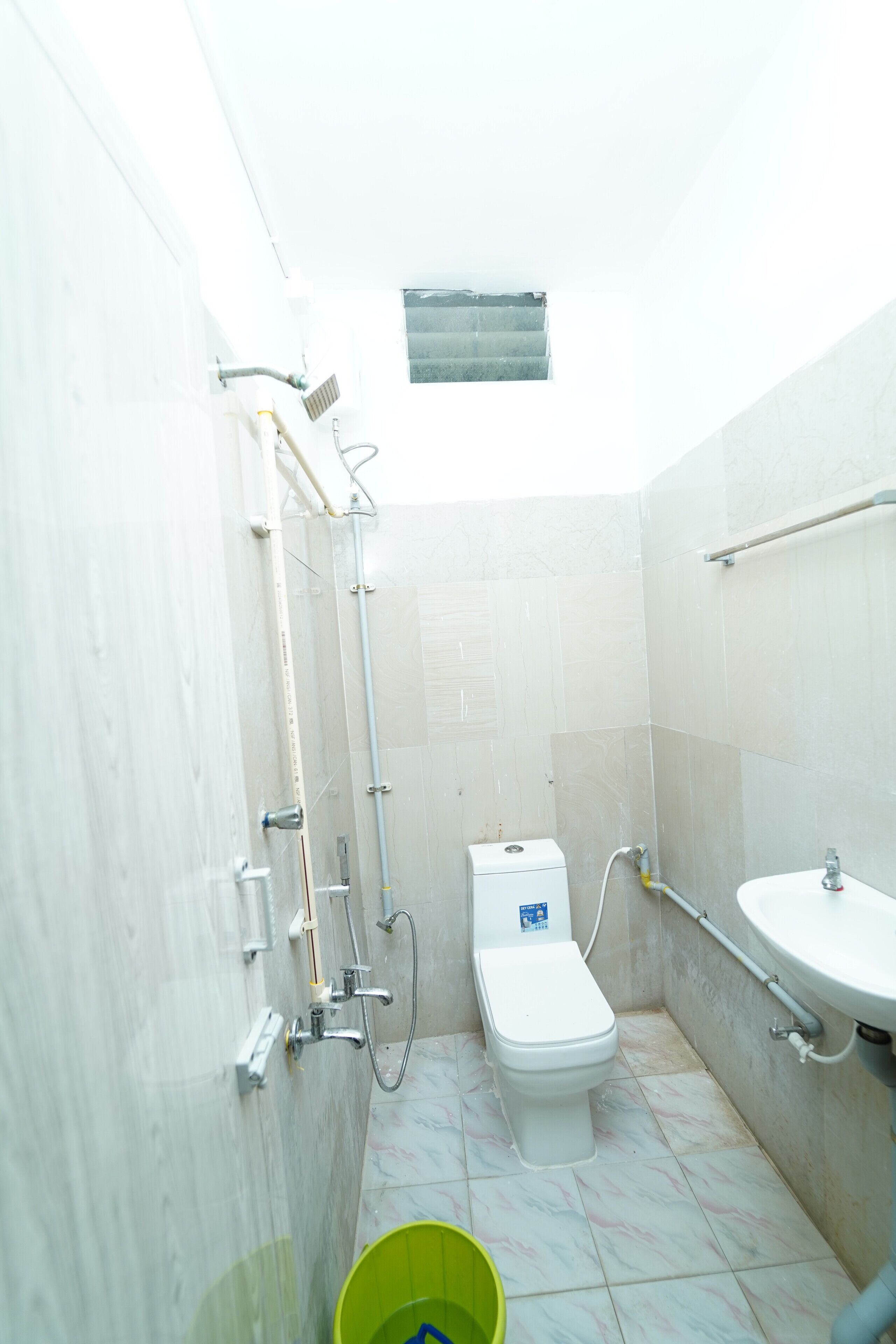 Un baño pequeño con inodoro, lavamanos y ducha.