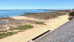 A coastal beach with a sandy shore, rocky areas, and a clear blue sky. - Le Rivage à Pornichet (Pornichet)