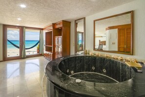 Ein geräumiges Badezimmer mit einer großen Badewanne, einem Waschtisch und einem Spiegel.