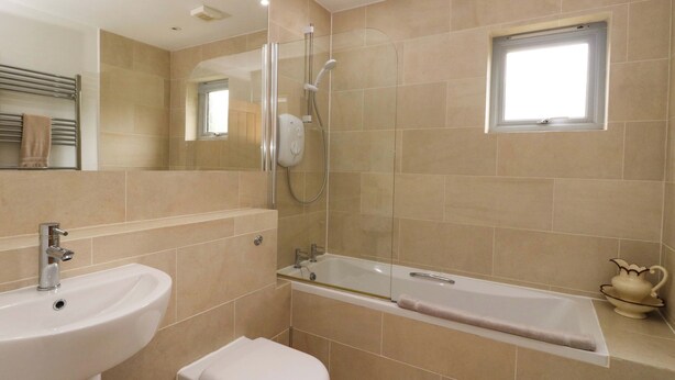 A modern bathroom with a bathtub, a toilet, and a sink. - Craigard (Aberfeldy)