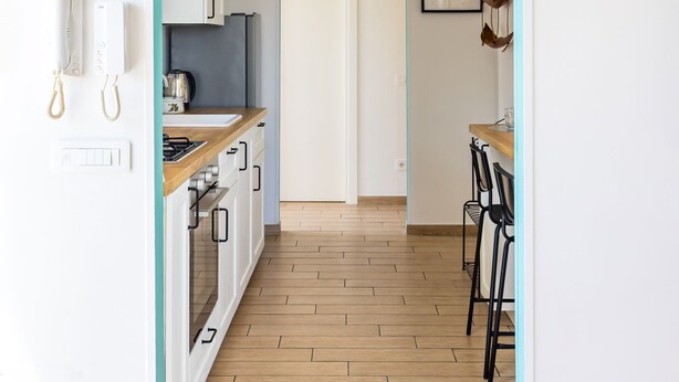 A kitchen with white cabinets, a wooden countertop, and a hanging light fixture. - Viewsuvio Two Apartments & Terraces (Naples)
