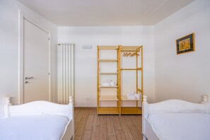 A hotel room with two beds, a wooden wardrobe, and a framed picture on the wall. - Viewsuvio Family Terrace (Naples)