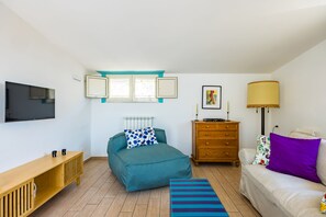 A bedroom with a bed, a dresser, a TV, a window, and a lamp. - Viewsuvio Family Terrace (Naples)