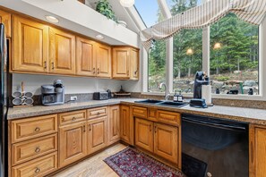 A kitchen with wooden cabinets, a coffee maker, a toaster, and a sink. - Downtown Breck Retreat| Deck + Trails + Hot Tub (Breckenridge)