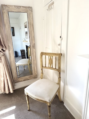 A room with a large ornate mirror, a wooden chair with a cushioned seat, and a white door. - Superb Hastings Old Town Duplex with parking and sea views (Hastings)