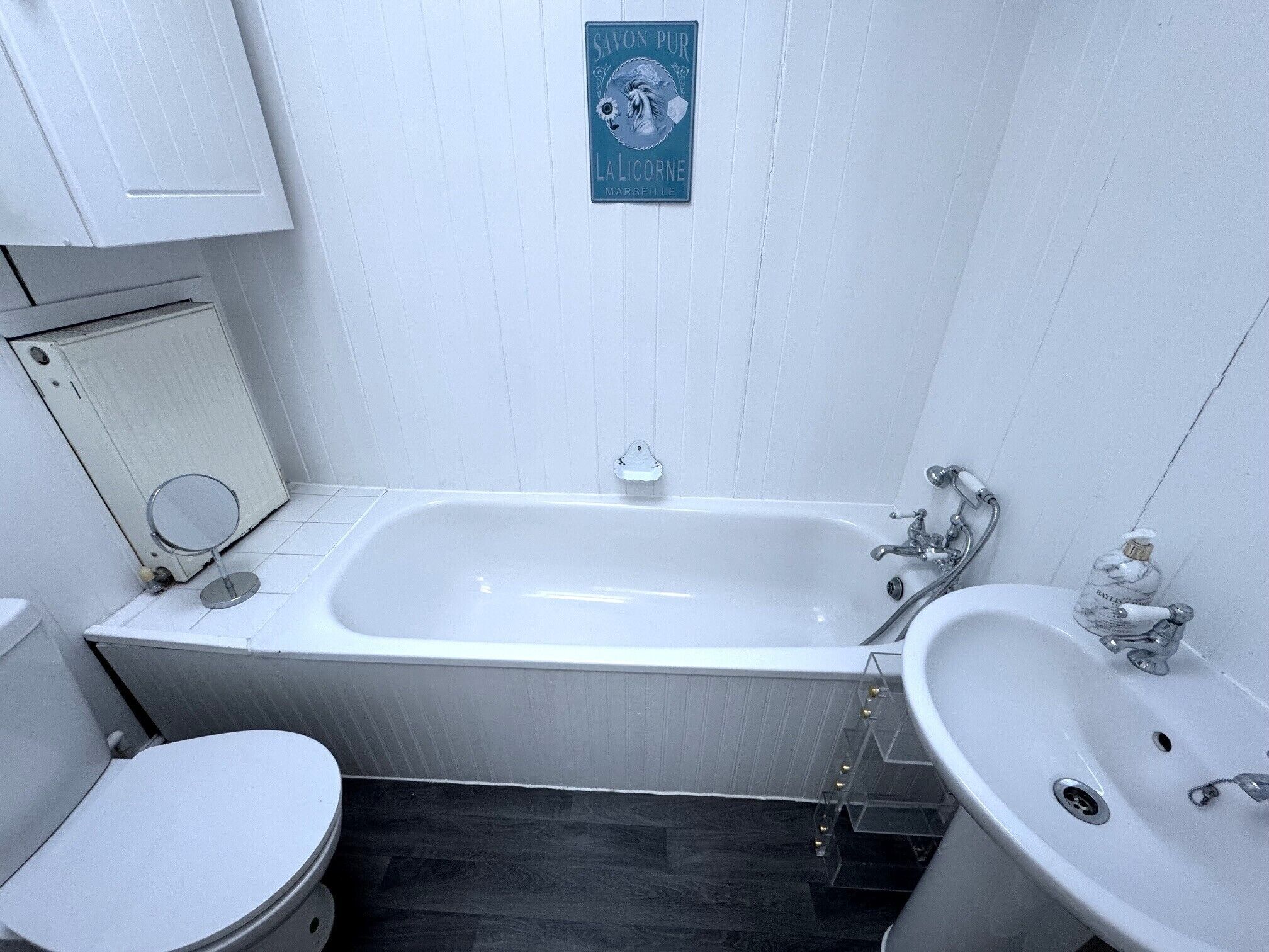 Et badeværelse med badekar, toilet og håndvask.