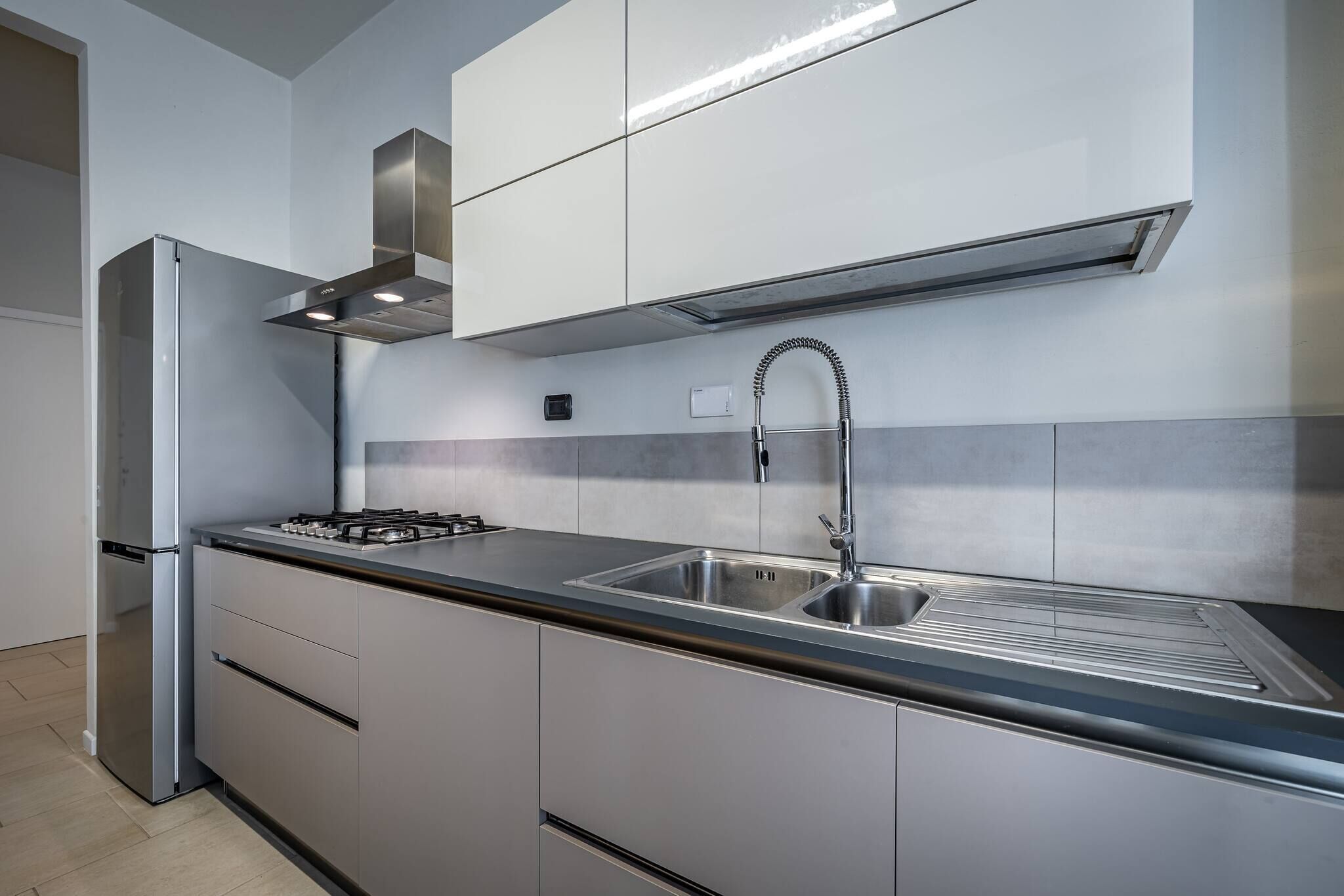 Una cocina moderna con electrodomésticos de acero inoxidable, un lavamanos doble y una estufa a gas.