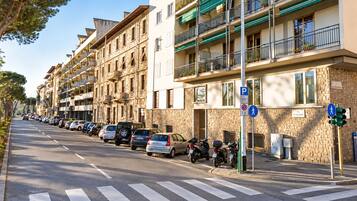 Katu, jonka varrella on useita kerrostaloja, parkkeerattuja autoja ja jalankulkijoiden suojatie.