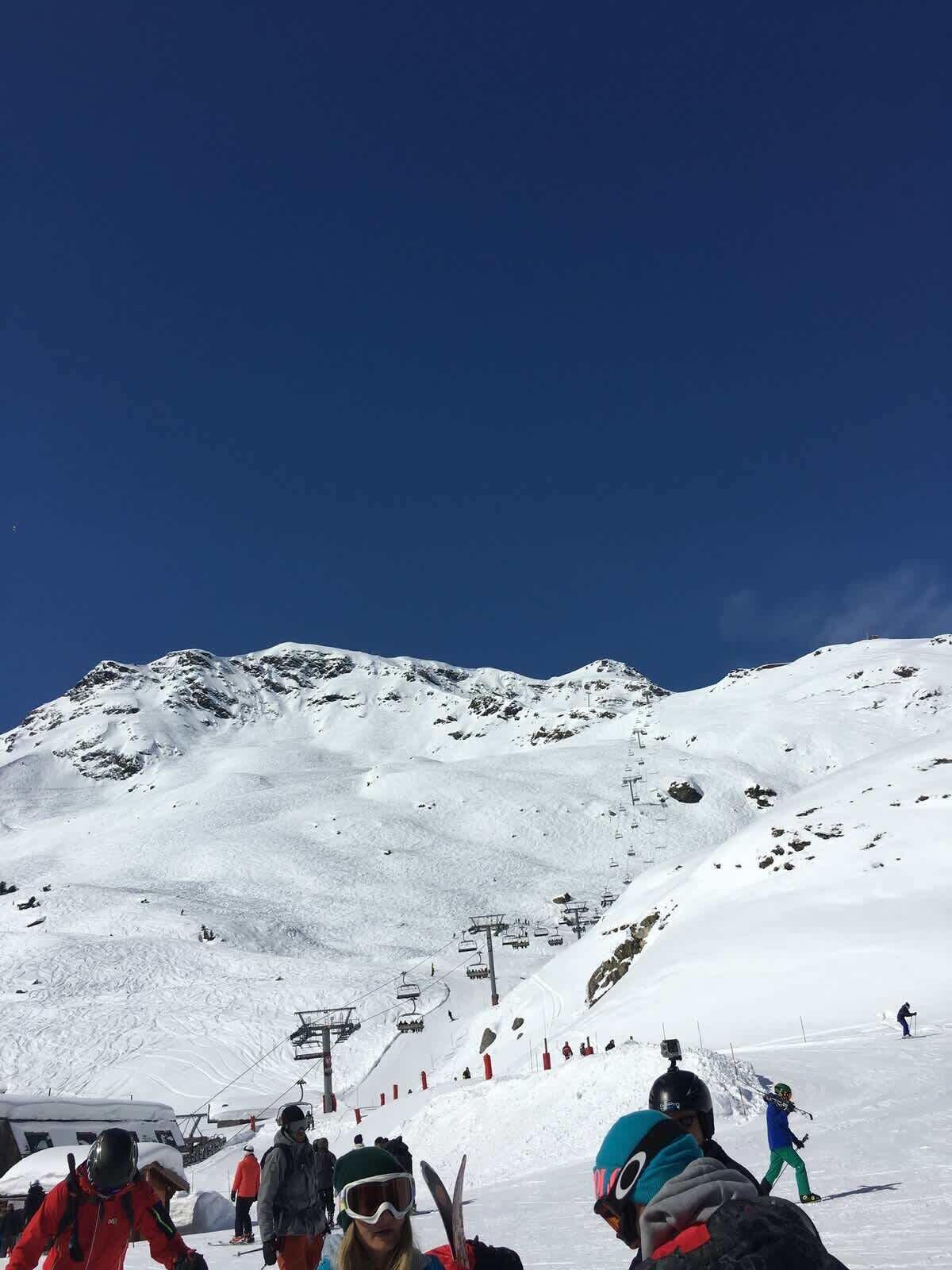 A snowy mountain slope with ski lifts and skiers.