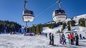 A ski lift with two cabins labeled 'les Vallées' and 'COURCHEVEL' against a snowy mountain backdrop. - Courchevel 1850 -3 Chambres, Balcon, Ski aux Pieds (Courchevel)