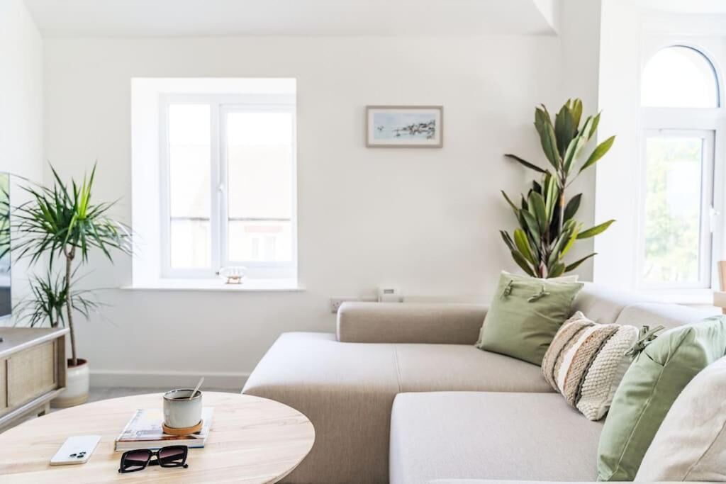 A modern living room with a sofa, a coffee table, and a window.