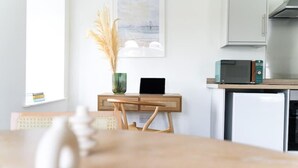 A kitchen with a microwave, a small cabinet, and a vase with dried plants. - Newport Ship's Nook (Newport)