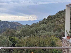 Ein Balkon mit Blick auf eine Berglandschaft und ein Gewässer.
