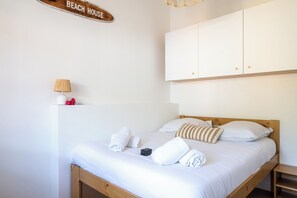 A bedroom with a bed, pillows, a lamp, and a sign that reads 'BEACH HOUSE'. - House with shared pool in Moliets (Moliets-et-Maa)