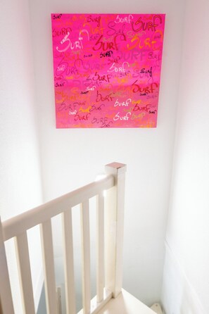 A white wooden railing in a corner with a pink wall featuring multiple instances of the word 'SURF' written in various styles and colors. - House with shared pool in Moliets (Moliets-et-Maa)