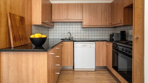 Una cocina con armarios de madera, lavavajillas, estufa y pileta.