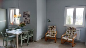Comedor con mesa, sillas, un florero con flores y adornos en la pared.