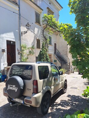 A beige SUV parked on a cobblestone street, surrounded by buildings with balconies and a clear blue sky. - Abruzzo Wine & Nature Escape: Cozy Apartment in Bolognano, Italy (Santa Maria del Monte, Pescara)