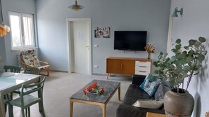 A living room with a sofa, a coffee table, a TV, a cabinet, and a chair. - Abruzzo Wine & Nature Escape: Cozy Apartment in Bolognano, Italy (Santa Maria del Monte, Pescara)