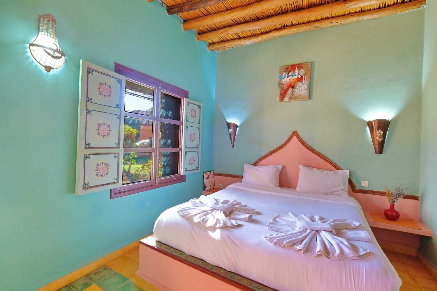 Un dormitorio con cama, ventana, decoración mural y techo decorativo.