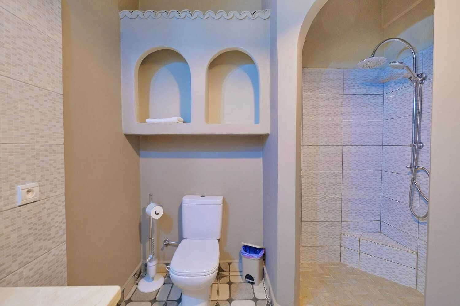 Une salle de bain équipée de toilettes, d’un bidet et d’une douche.