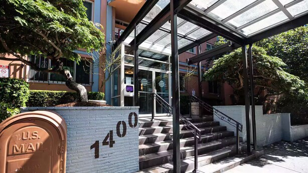 L'ingresso di un edificio con una tettoia in vetro, una cassetta postale per la posta statunitense e una scala che conduce all'ingresso.
