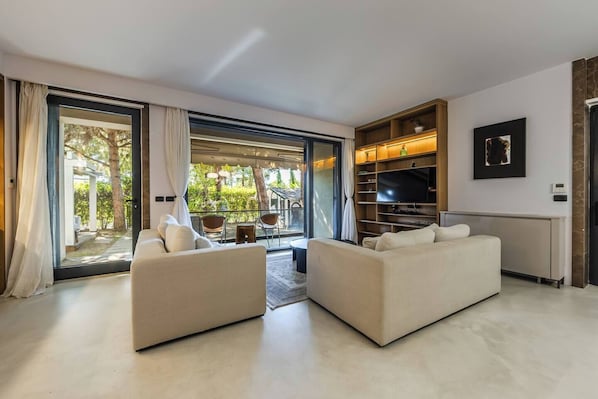 A modern living room with two sofas, a TV, and a bookshelf.