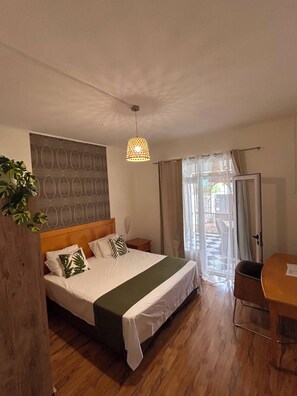 Une chambre d’hôtel avec un lit, une table de chevet, une lampe, des rideaux et une vue sur l’extérieur.