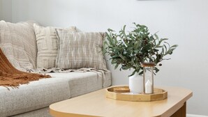 En stue med en sofa, et træbord og en potteplante.