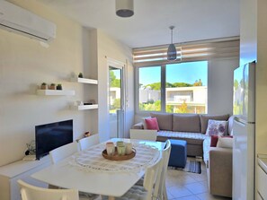 A modern living room with a dining area, a sofa, and a TV. - Lura 2 Holiday Homes 181 (Gjiri Lalzit)